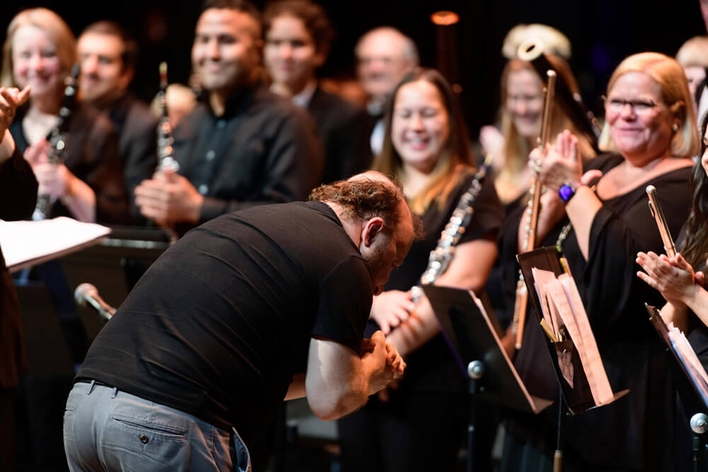 conductor bowing to orchestra