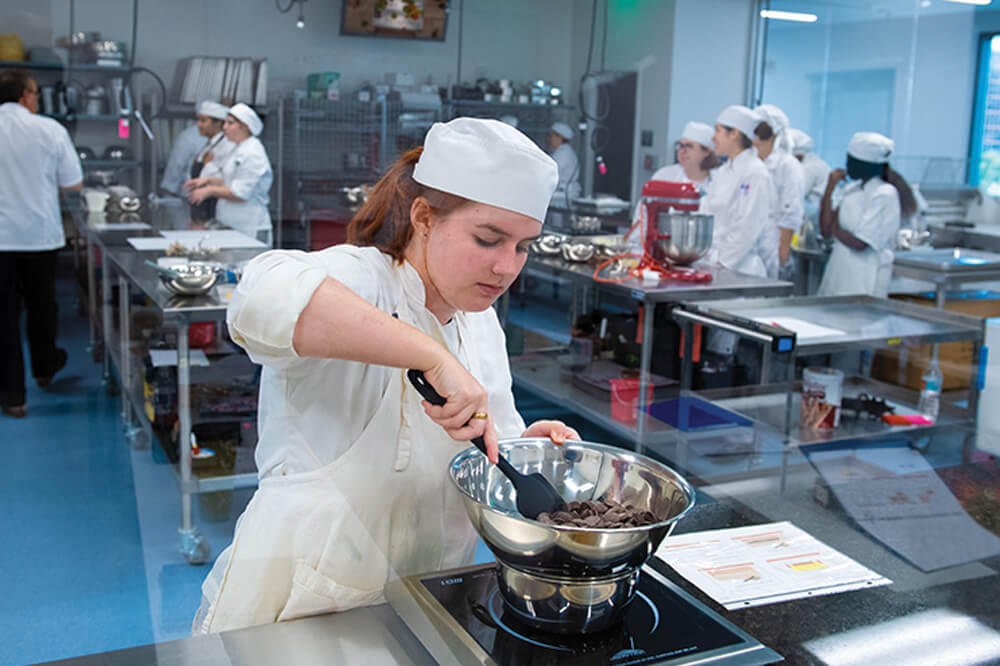 Female student preparing recipe in kitchen lab